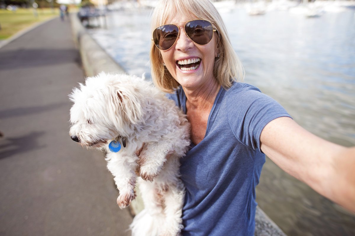 Mature woman taking selfie with dog