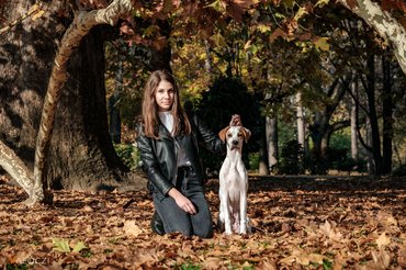 Egy lány a kutyájával az erdőben fotózkodik