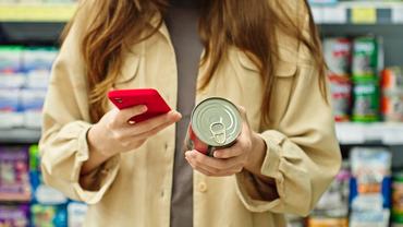 Nő kutyakonzerv összetevőit nézi