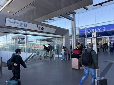 Paris, France - April 7, 2026: Travelers with luggage navigating the modern Orly Airport Metro Line 14 station, experiencing the convenience of public transportation connecting to Paris, France
