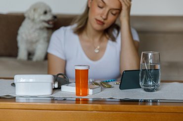 egy fejfájós nő a háttérben kutyával