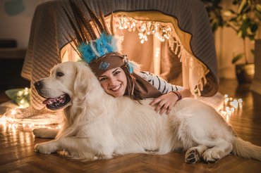 egy nő indián fejdíszben kutyával