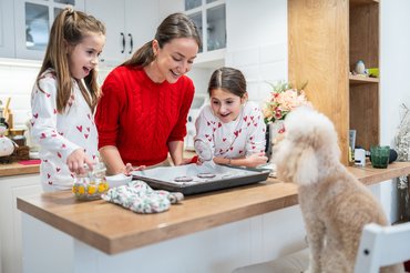 konyhában egy anyuka gyerekeivel és egy kutyával