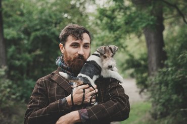 szakállas férfi erdőben kutyájával